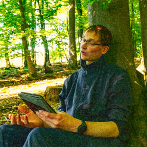 Christian Scholz, wie er als Trainer während eines Seminars im Wald, den Teilnehmenden etwas erklärt.